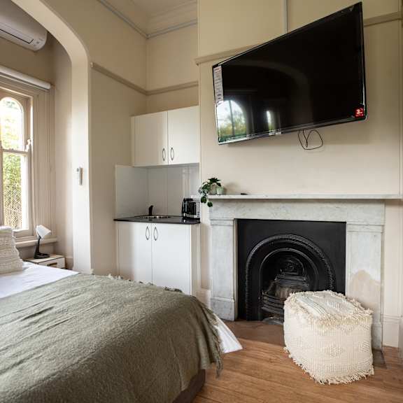 a bedroom with a fireplace and a tv above it