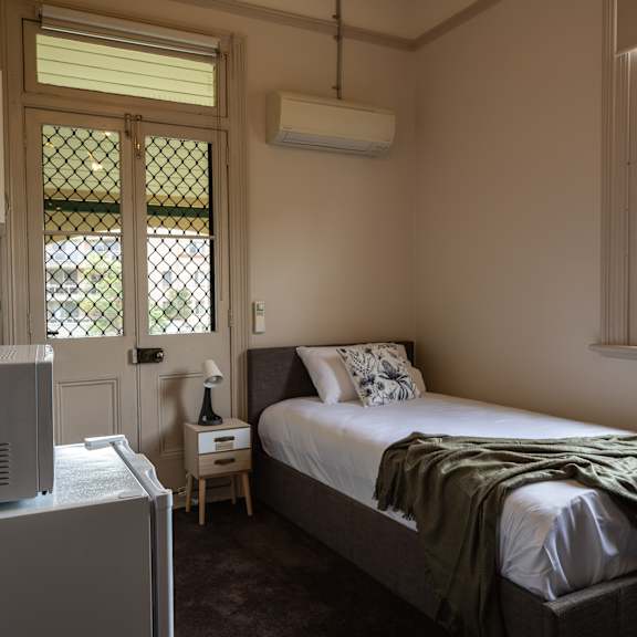 a small bedroom with a bed and a window