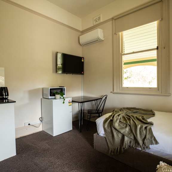 a small bedroom with a bed and a television
