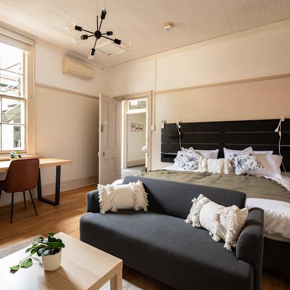 a bedroom with a bed and a desk and a window