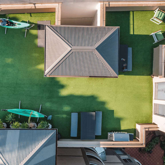 a birdseye view of the backyard of a house with a green lawn and