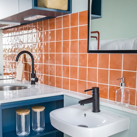 a white sink in a bathroom with orange tiles