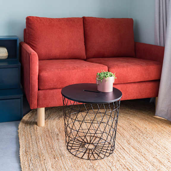 a living room with a red couch and a round table