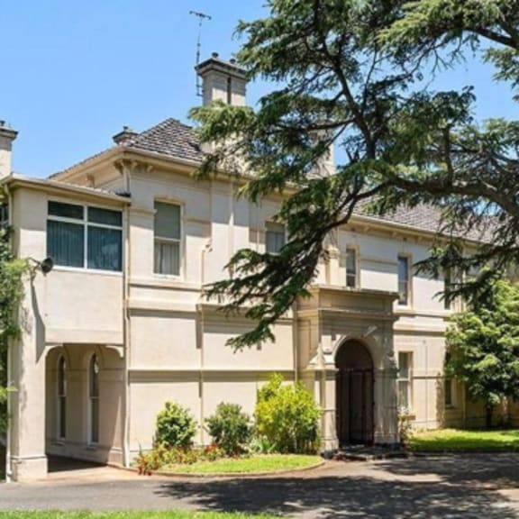 a mansion with a large tree in front of it