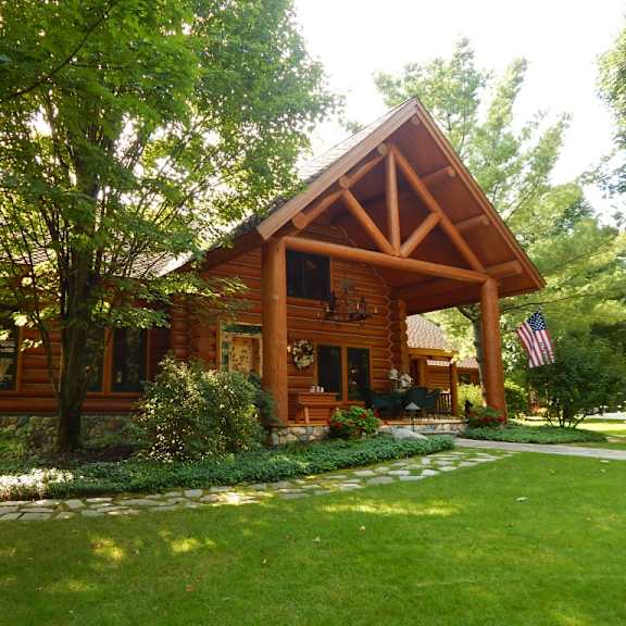 a large log cabin with a large lawn in front of it