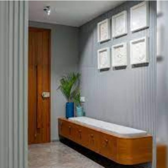 a room with a bench and pictures on the wall