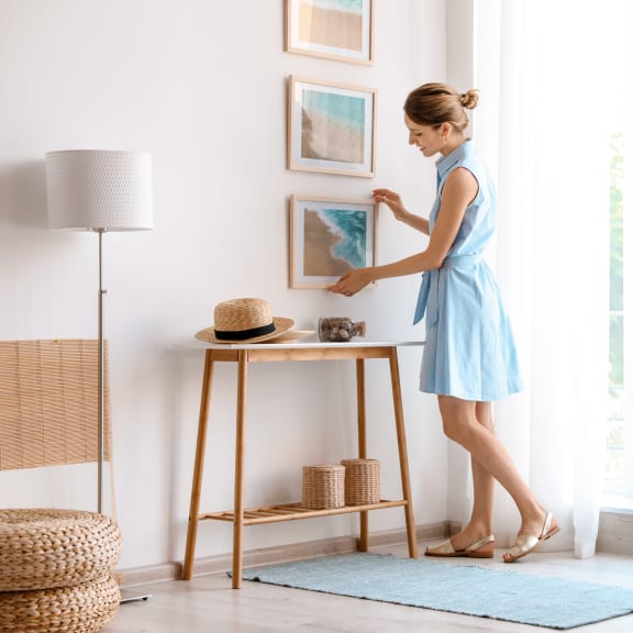 a woman in a blue dress puts a hat on a table