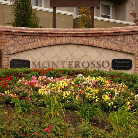 a sign that says "monterosso" is surrounded by flowers.