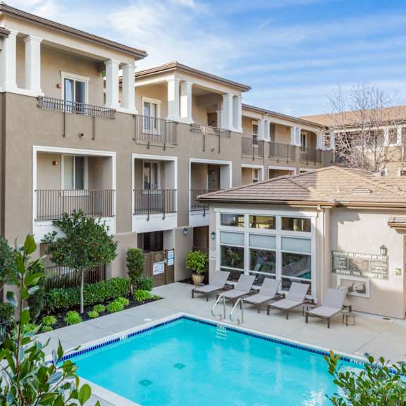 a large apartment complex with a pool in the foreground.