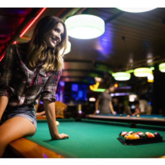 a woman sitting on a pool table