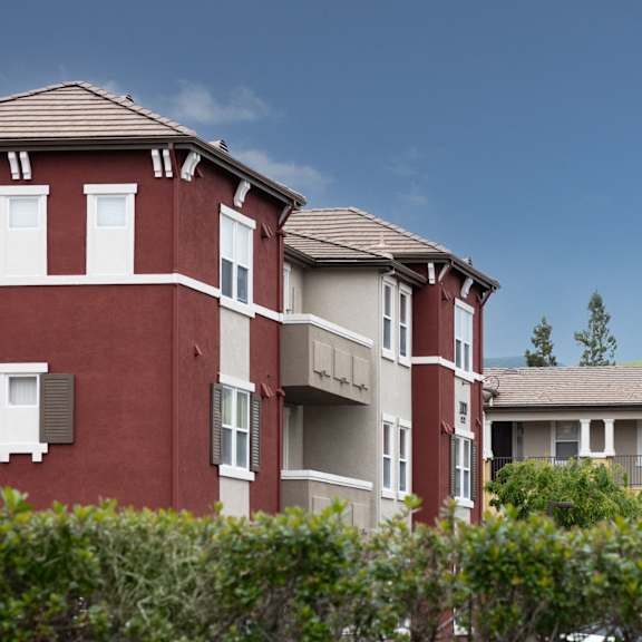 apartment buildings with green shrubbery in front.