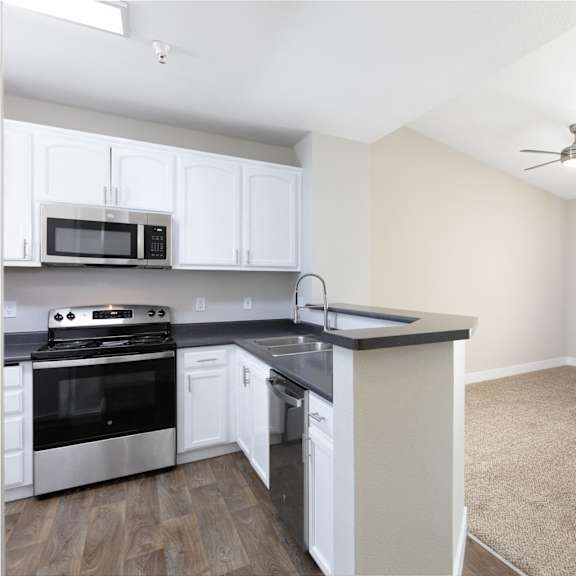 a kitchen with white cabinets and a black countertop.