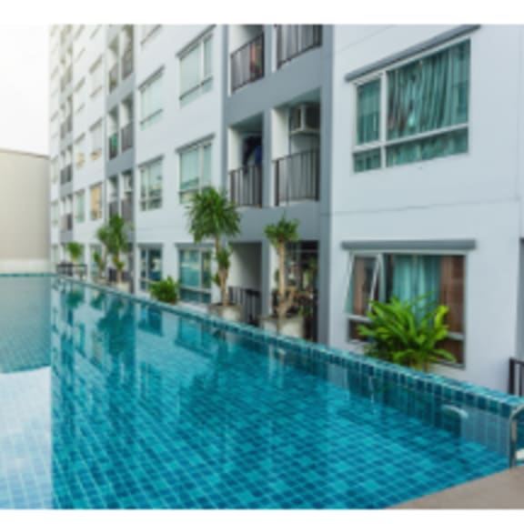 alt-luxurious swiming pool surrounded with apartment buildings