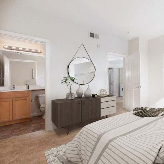 a bedroom with a large bed and a vanity with a mirror.