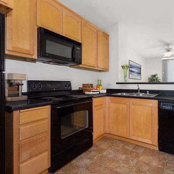 a kitchen with wooden cabinets and black appliances.