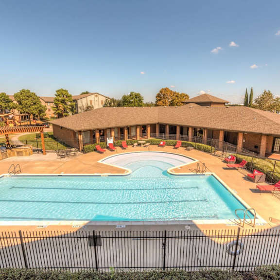 a large outdoor swimming pool surrounded by a black fence.