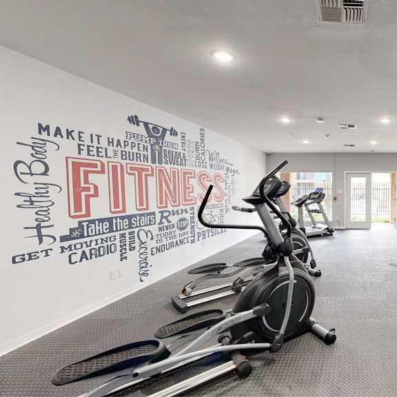 a gym with a wall of fitness related words.