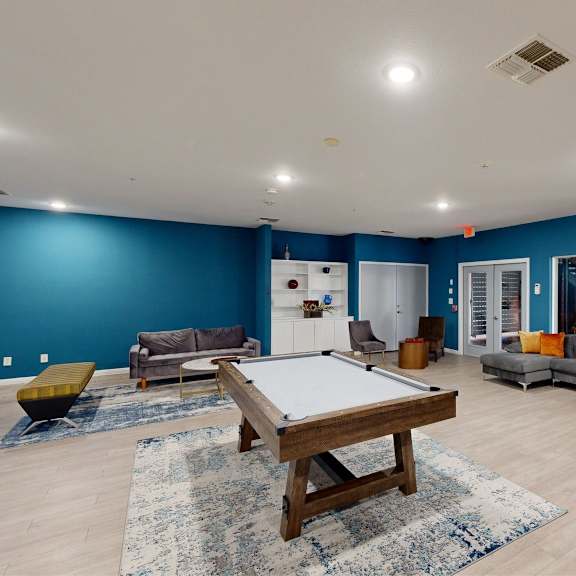 a room with a pool table and a couch.