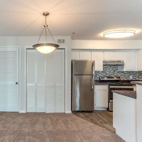 a kitchen with white cabinets and a stainless steel refrigerator.