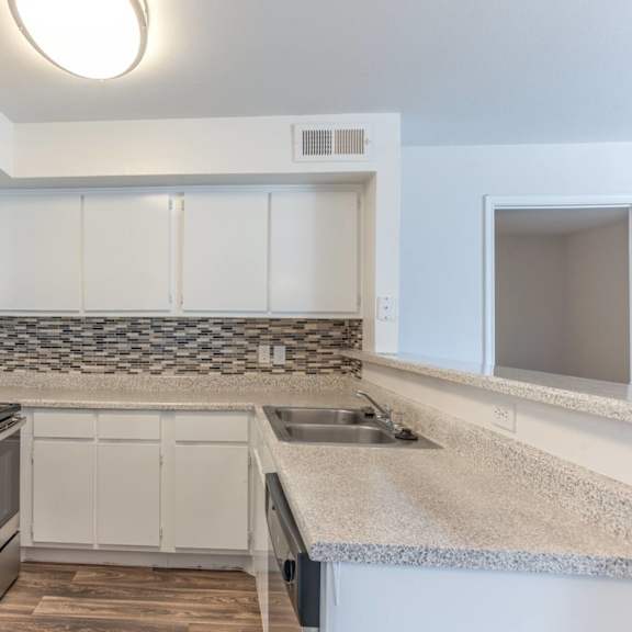 a kitchen with white cabinets and a granite countertop.