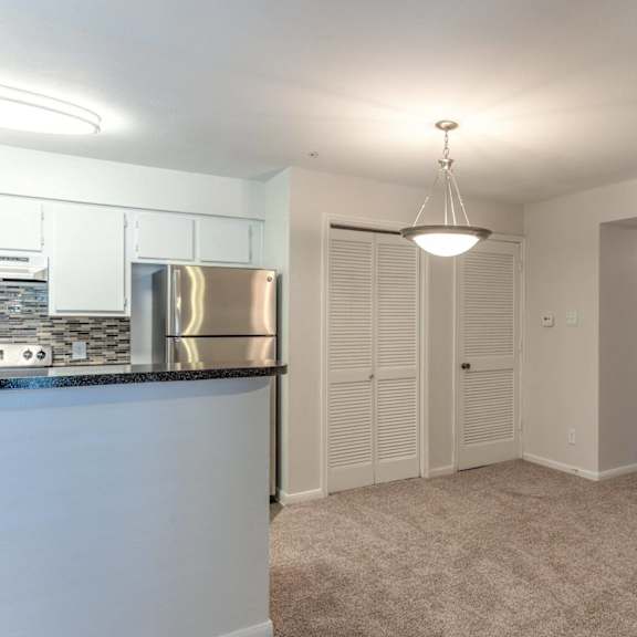 a kitchen with white cabinets and a stainless steel refrigerator.