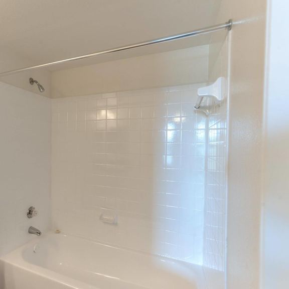 a white bathroom with a toilet, tub, and shower.