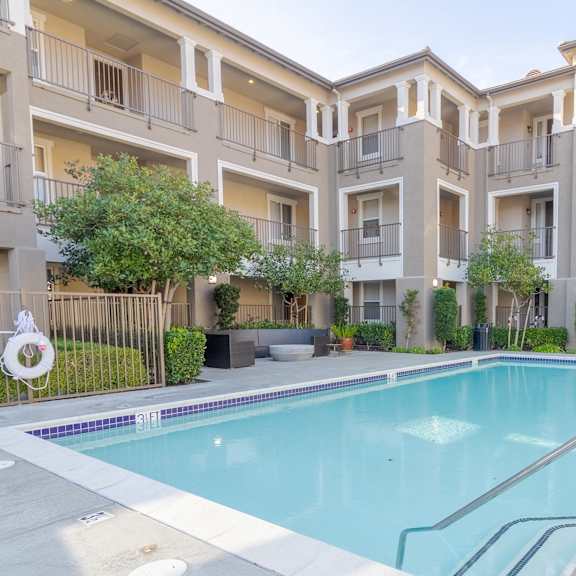 a swimming pool in front of apartment buildings.