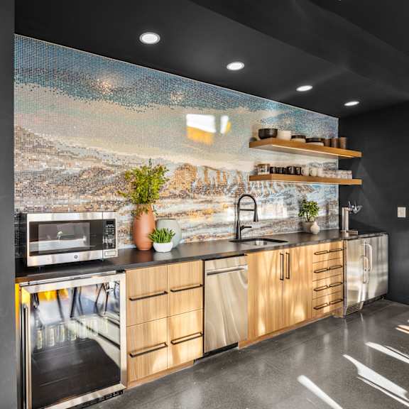 a kitchen with a large painting on the wall.