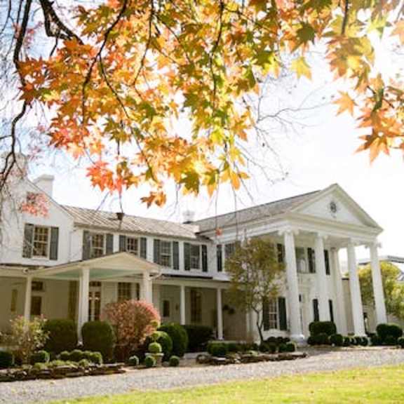 a large white house with a tree in front of it