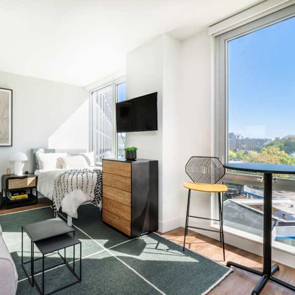 a living room with a couch and a bed and a window