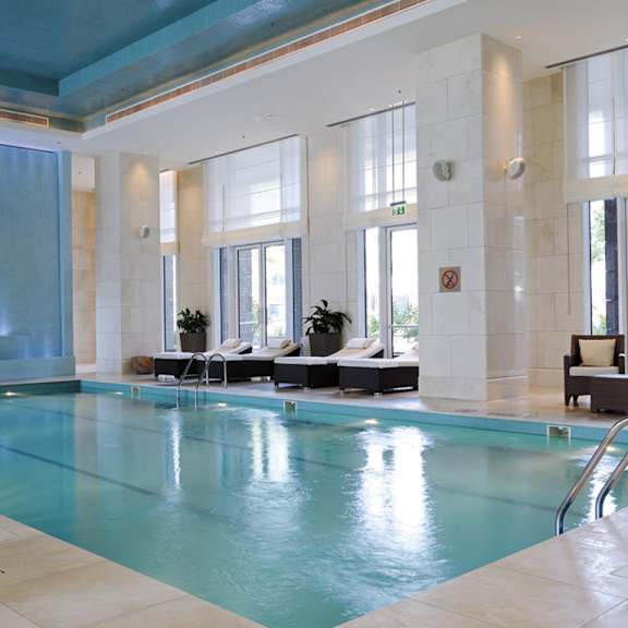 a swimming pool in a hotel with a blue ceiling and light blue water