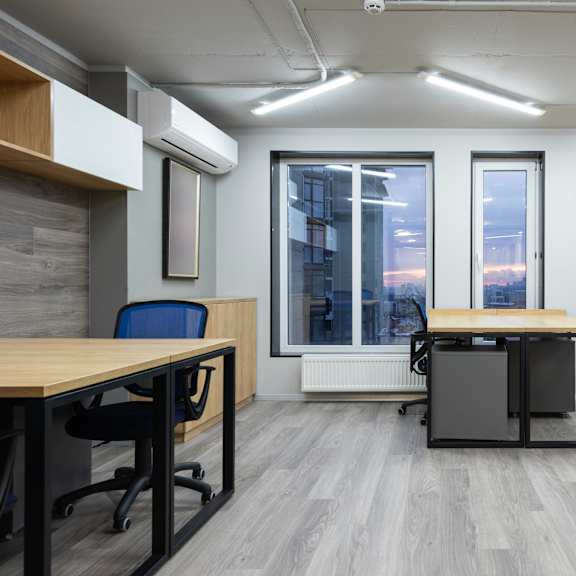 a modern office space with a wooden desk and blue chairs.