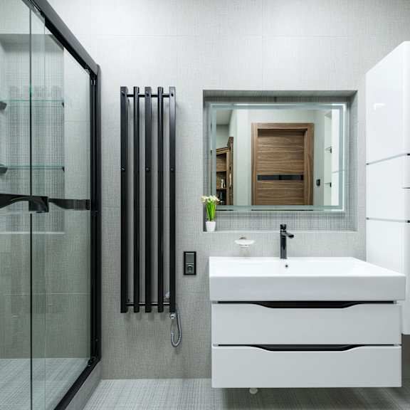 a modern bathroom with a white sink and a glass shower.