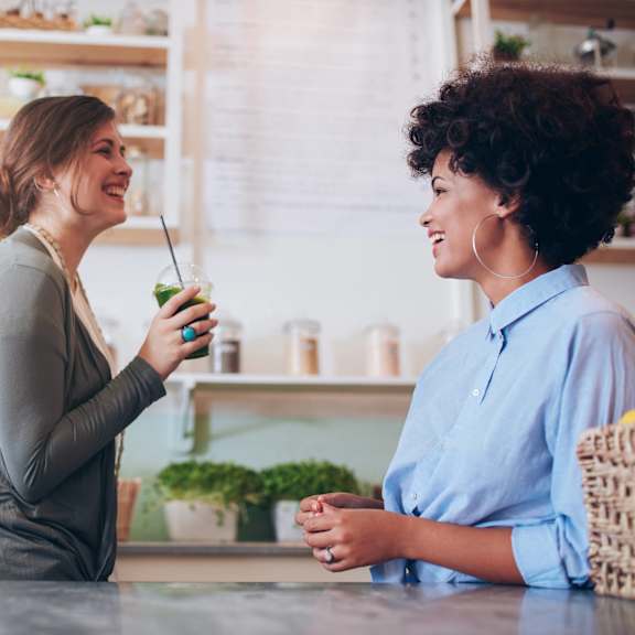 two women sitting in a kitchen having a conversation