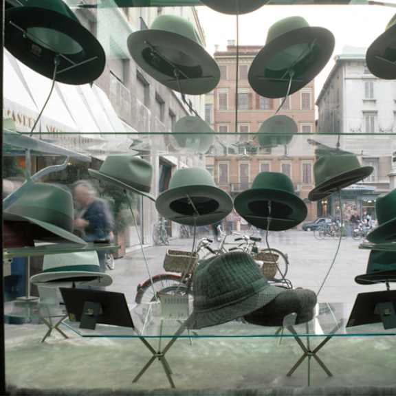 a person sitting in a chair looking at a display of hats