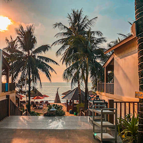 a sunset view from a balcony overlooking the ocean.