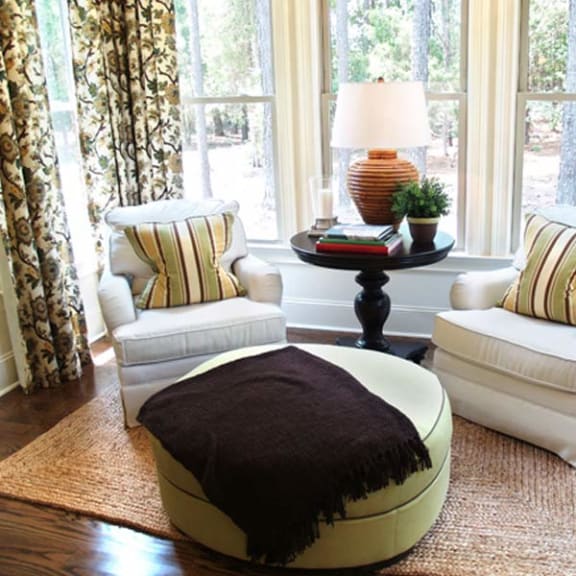 a living room with two chairs and a ottoman