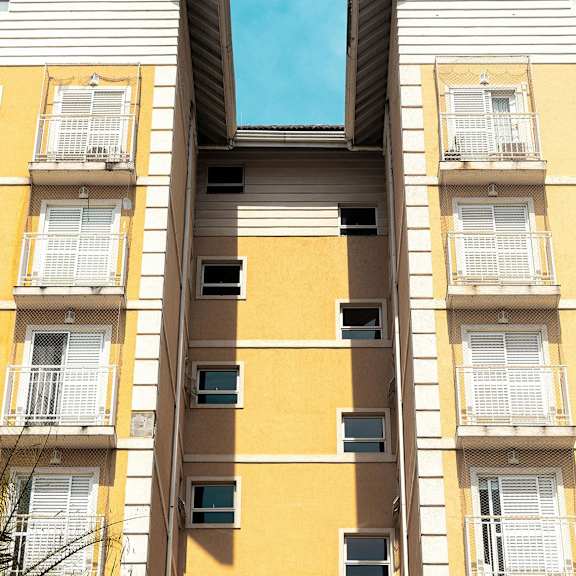 two buildings with yellow and white facades and balconies.