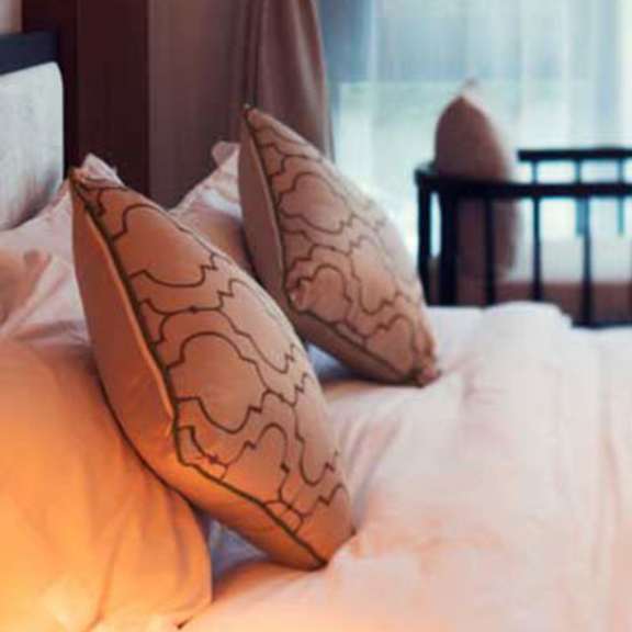 a bed with a bunch of pillows on it