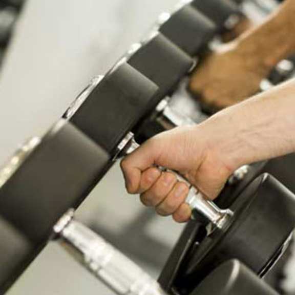 a hand is holding onto a bar in a gym