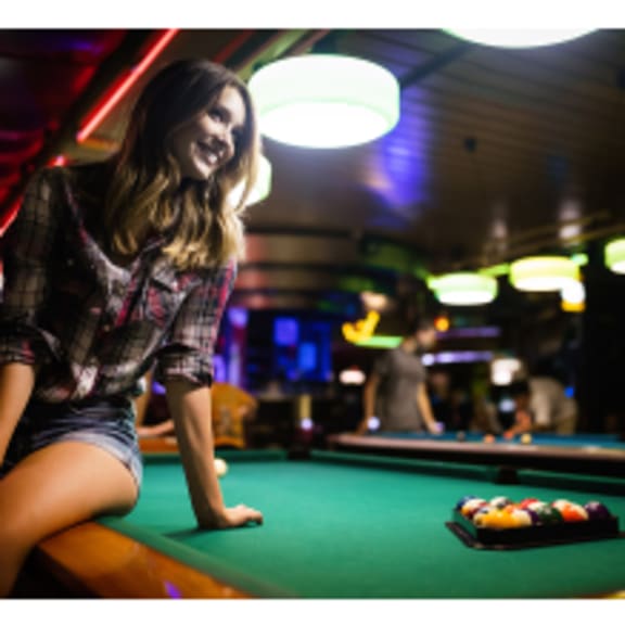 a woman sitting on a pool table