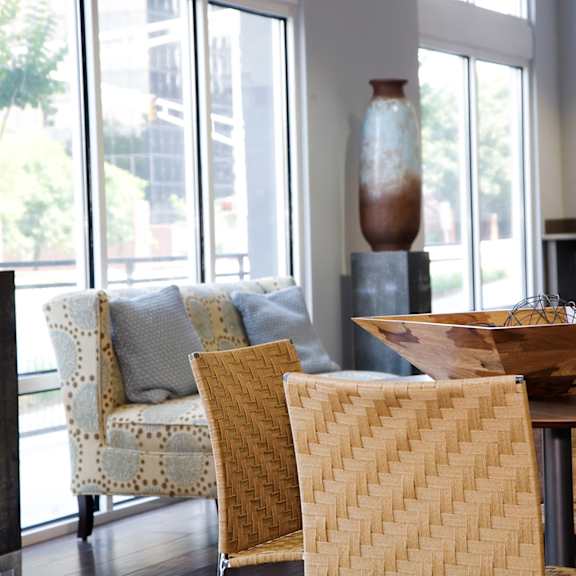 a brown vase sits on a table in a room with a large window.