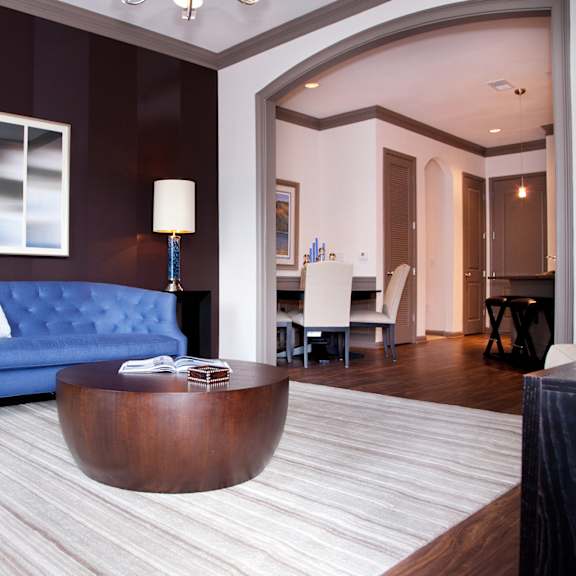 a blue sofa sits in a room with a wooden coffee table.
