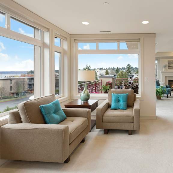 a living room with a fireplace and a view of the street outside.