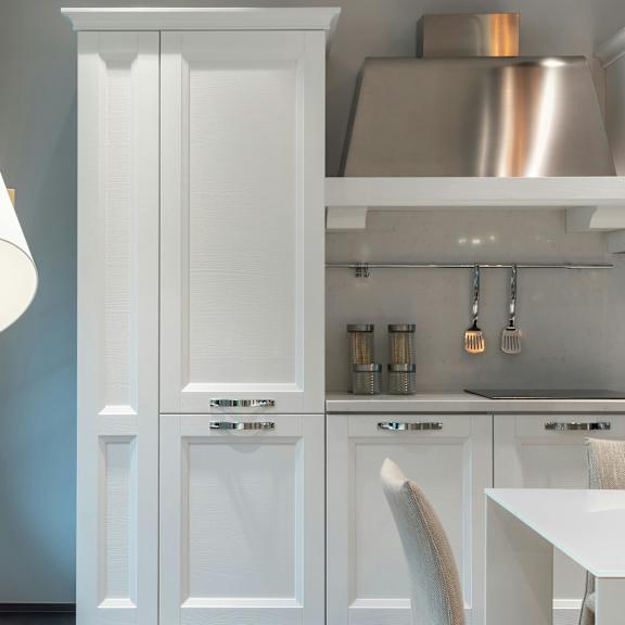 a white lamp stands next to a white cabinet in a kitchen.