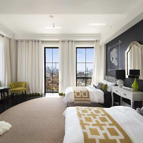 a bedroom with a large bed and a yellow chair.