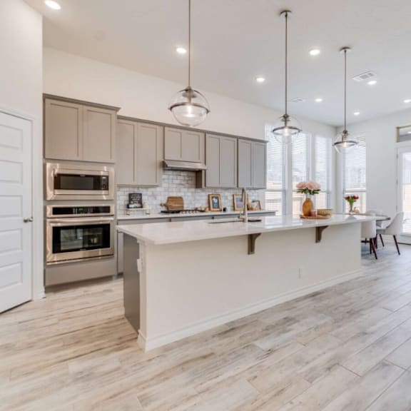 a modern kitchen with a white island and a refrigerator on the left at bluebell ridge, colorado 80202