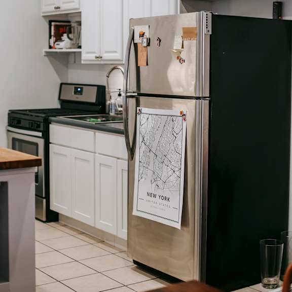 a black refrigerator with a magnet on it that says new york.