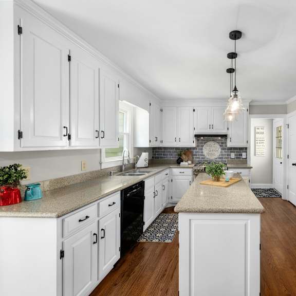 a kitchen with white cabinets and a wooden island.