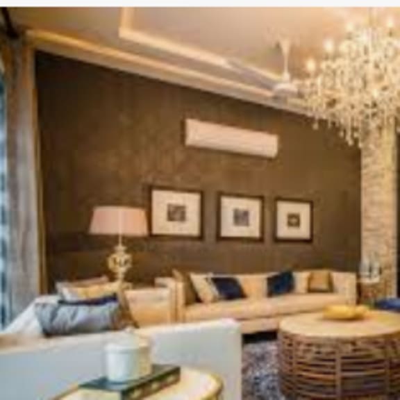 a living room with a white sofa, a wooden coffee table, and a chandelier.